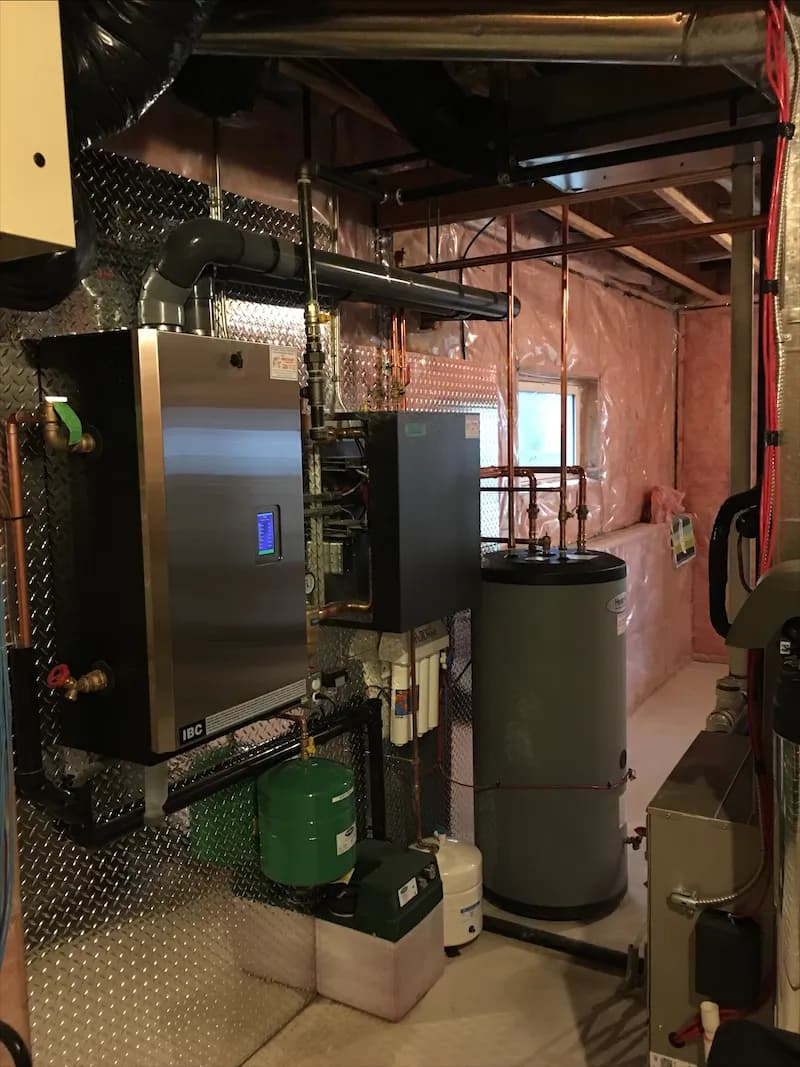 Wall-mounted condensing boiler and storage tank installed in an unfinished basement with insulated walls